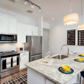 Model Kitchen at Ten45 Suwanee, GA 30024 spacious kitchen with an island, ample counter-space & on wood-style flooring