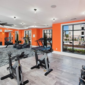 Fitness Center at Ten45 Suwanee, GA 30024 fitness center with equipment, plenty of spacious areas, accent-colored walls & bright lighting from multiple windows